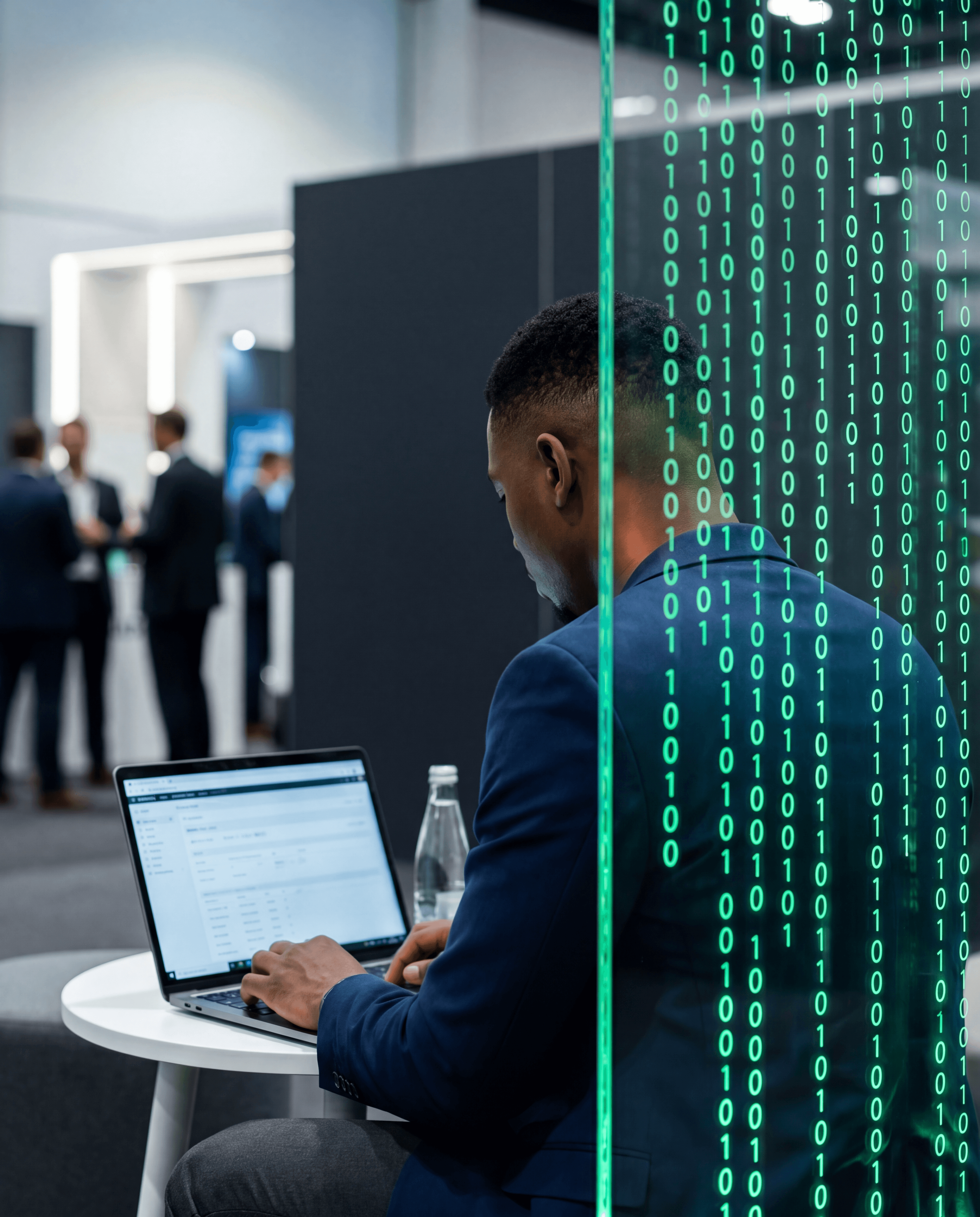 Karamo de dos travaillant face à un mur de code binaire vert